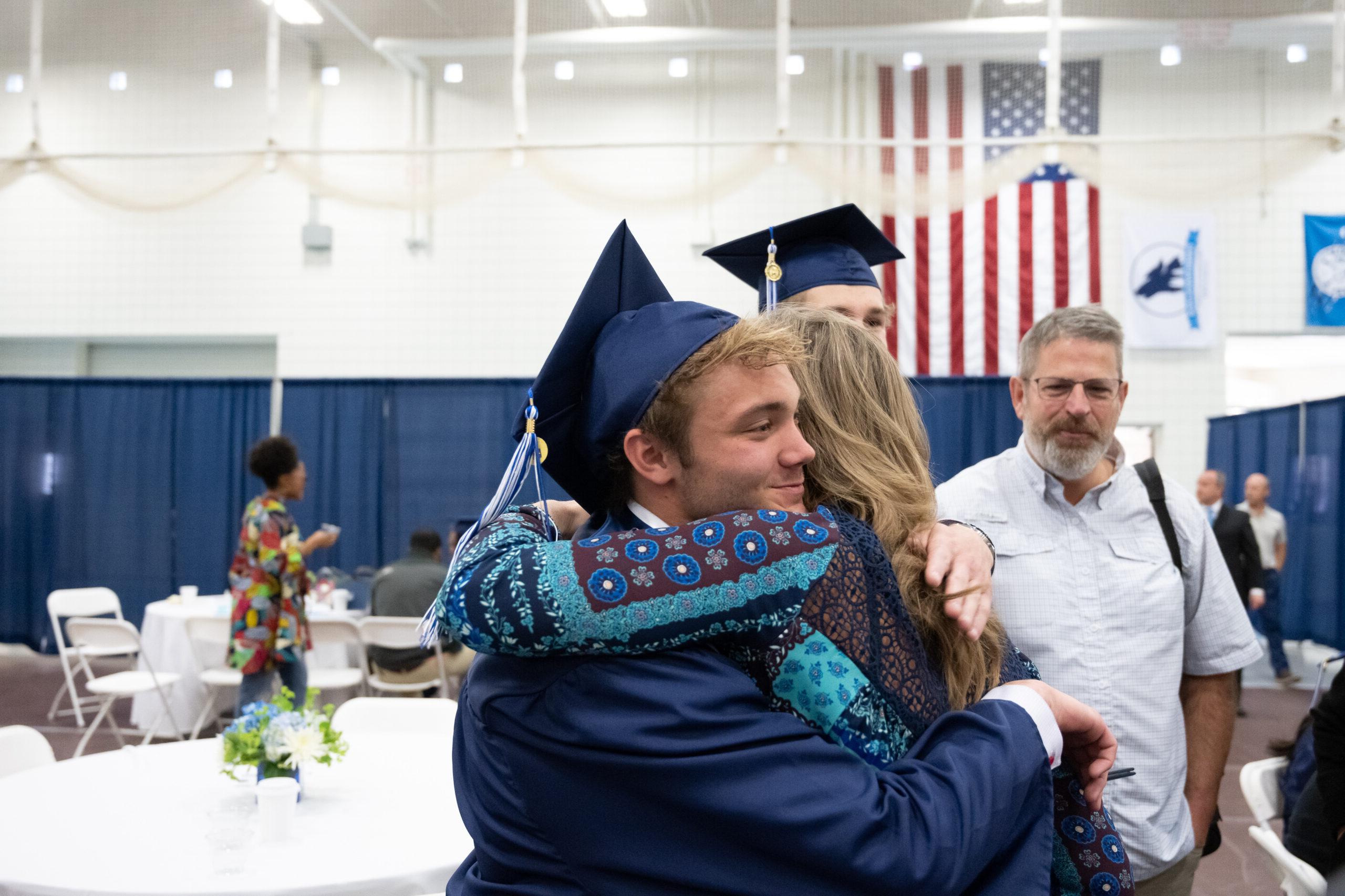 Parent hugging their student at graduation